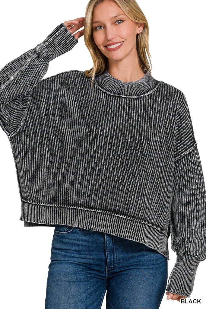 Woman wearing a gray ribbed sweater and blue jeans on a white background