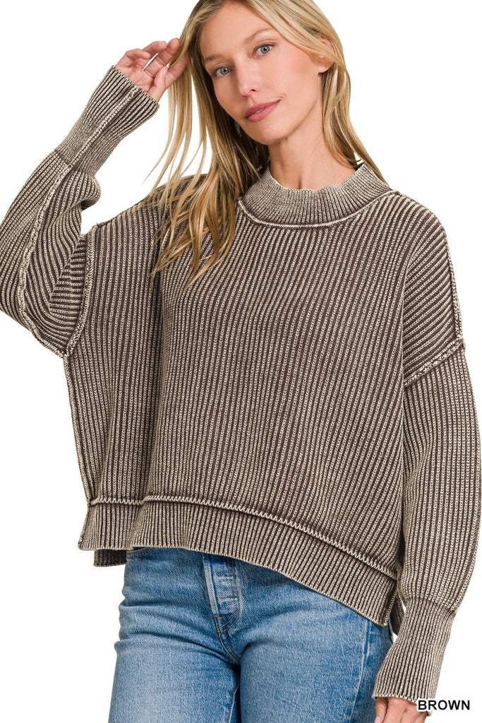 Woman wearing a brown ribbed sweater and blue jeans on a white background
