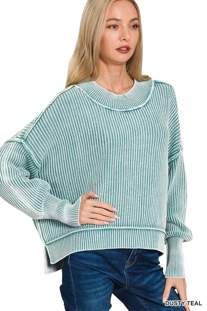 Woman wearing a dusty teal sweater with a white background