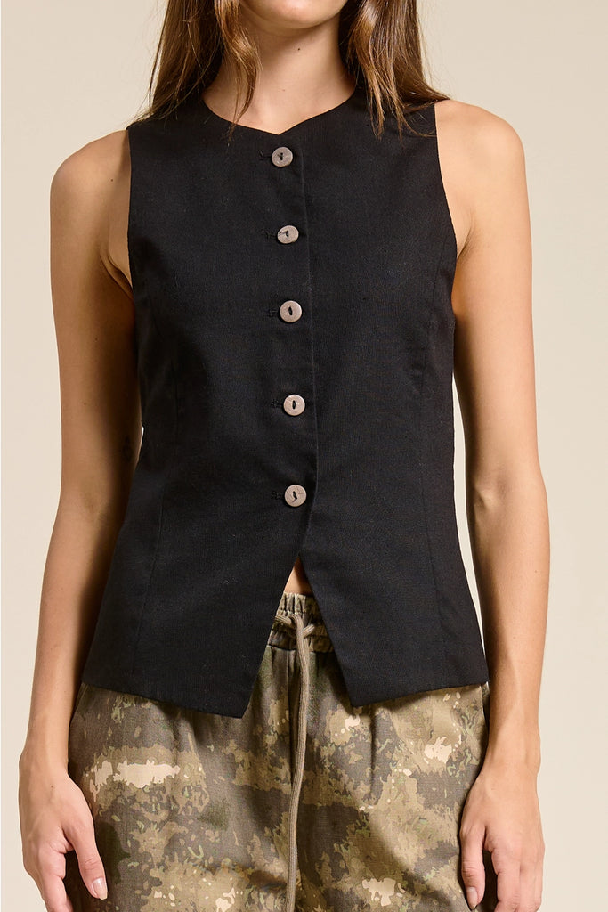 Black sleeveless button-up top worn by a person on a beige background