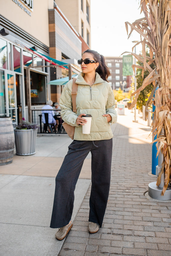 Woman wearing a green quilted zippered pullover jacket