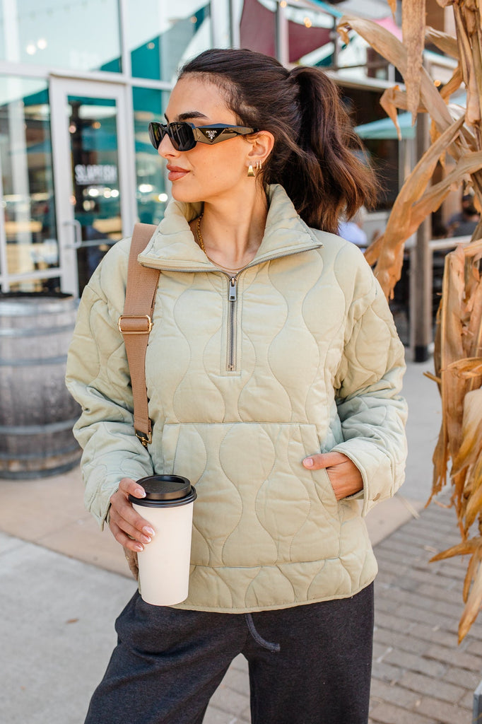 Woman wearing a green quilted zippered pullover jacket