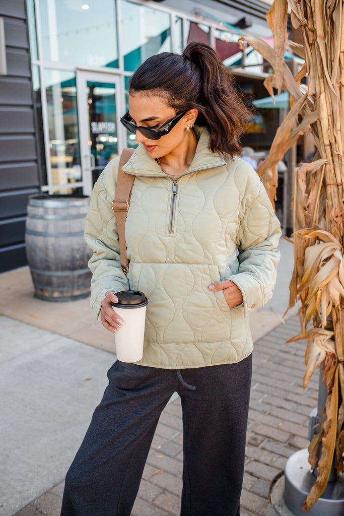 Woman wearing a green quilted zippered pullover jacket