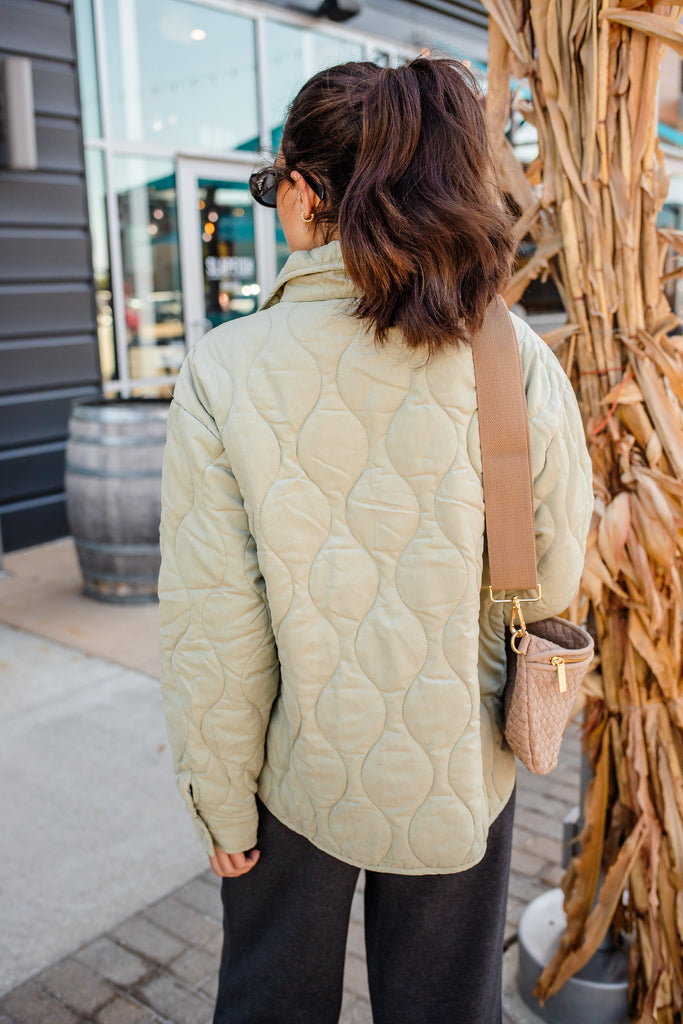 Woman wearing a green quilted zippered pullover jacket