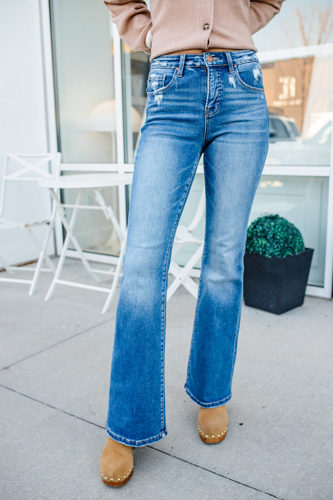 Person wearing blue jeans and a beige cardigan